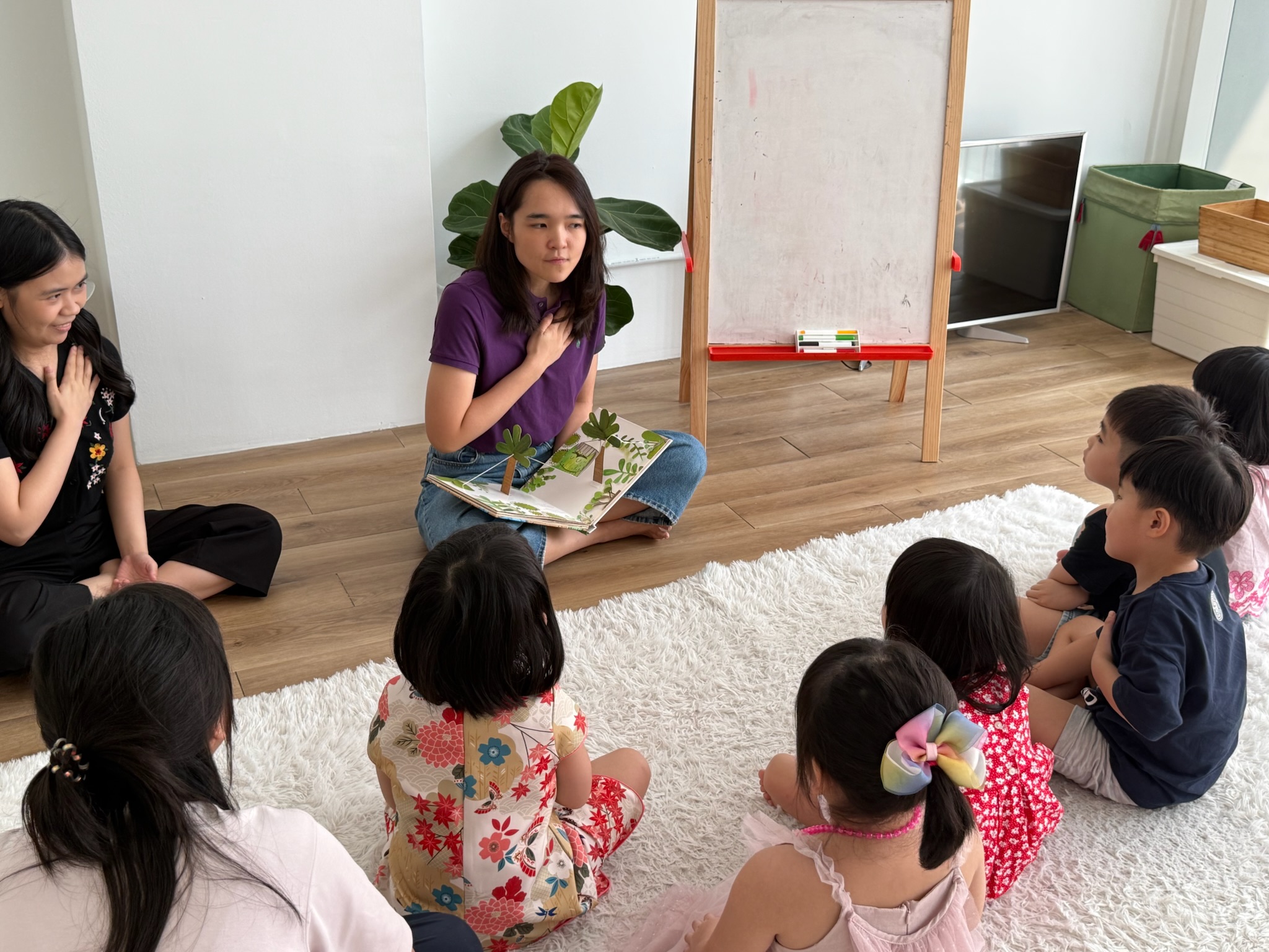 Educator leading circle time with a pop-up book and a group of children