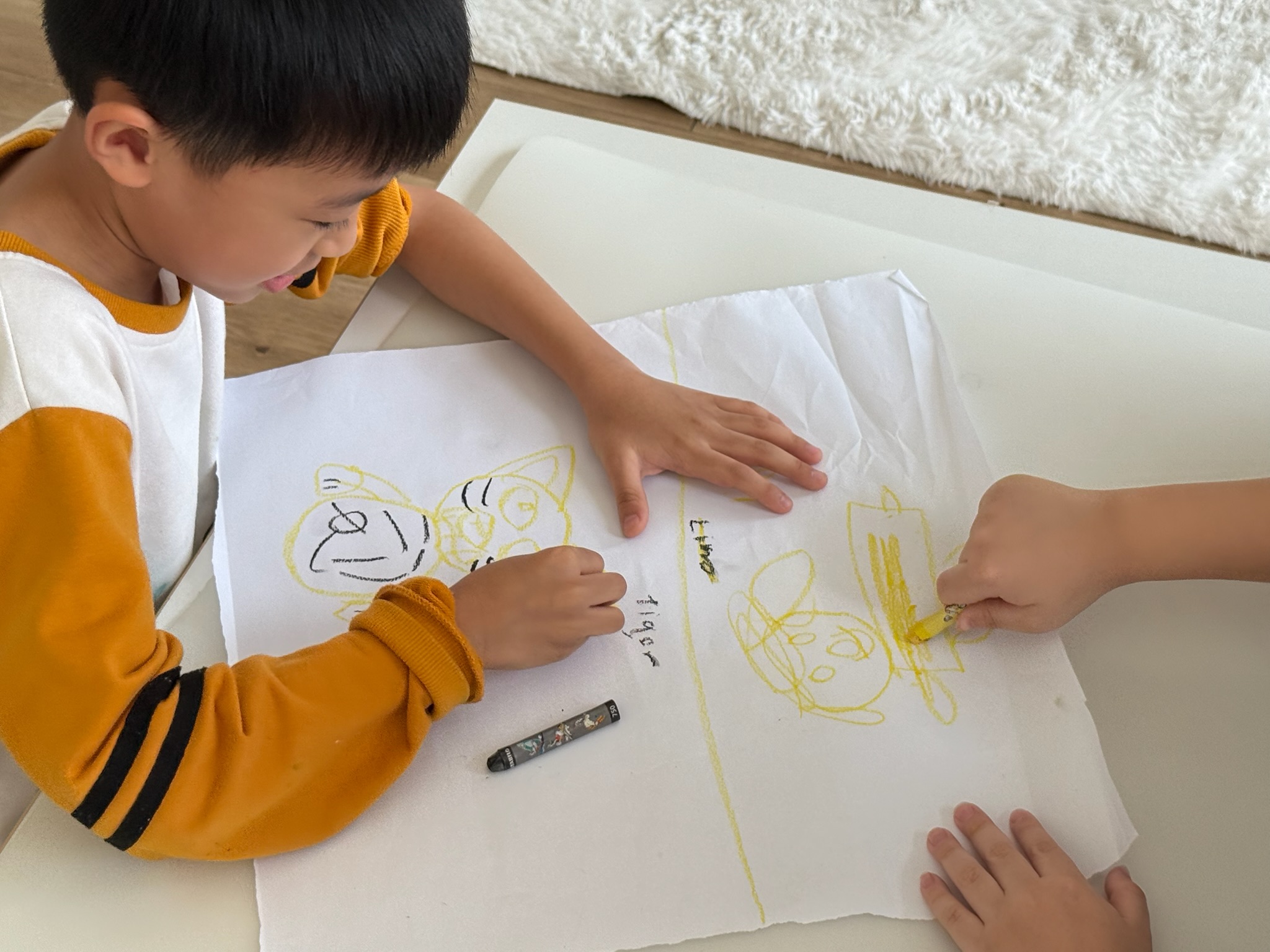 A child concentrating on a crayon drawing during a creative activity