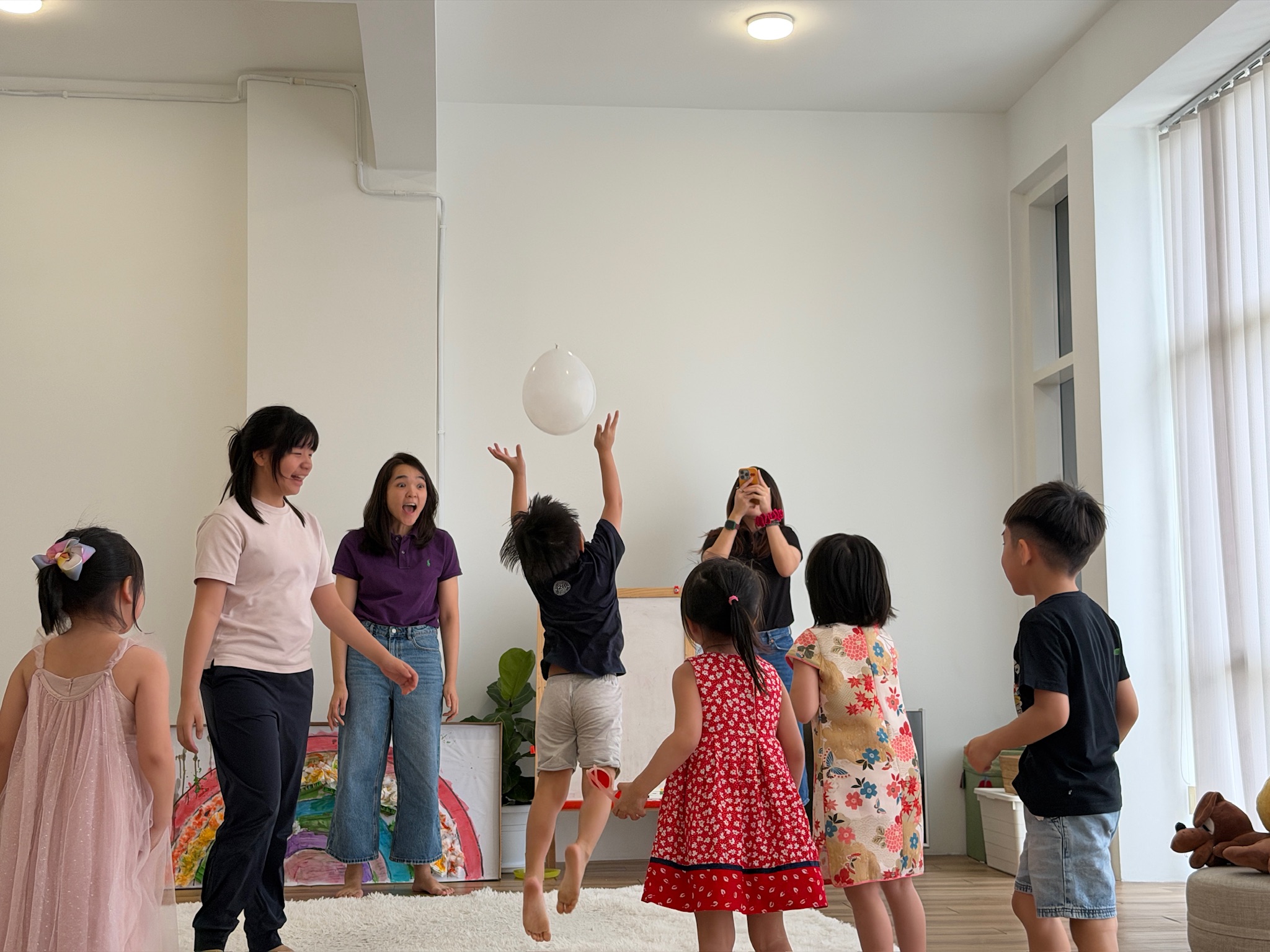 Children and facilitators playing a balloon game as a warm-up